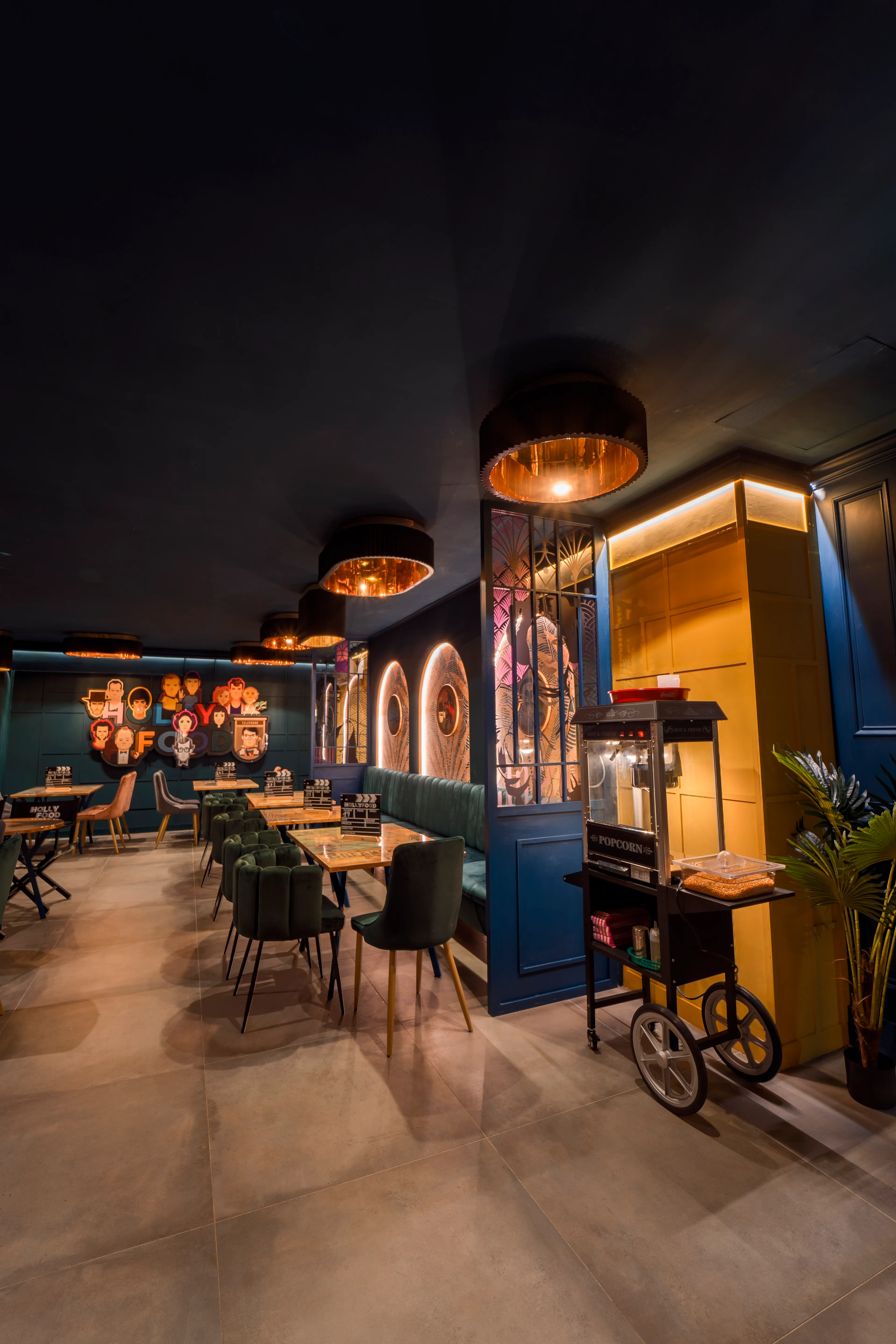 La sala di Hollyfood con il carrello dei popcorn e le illustrazioni a tema cinema